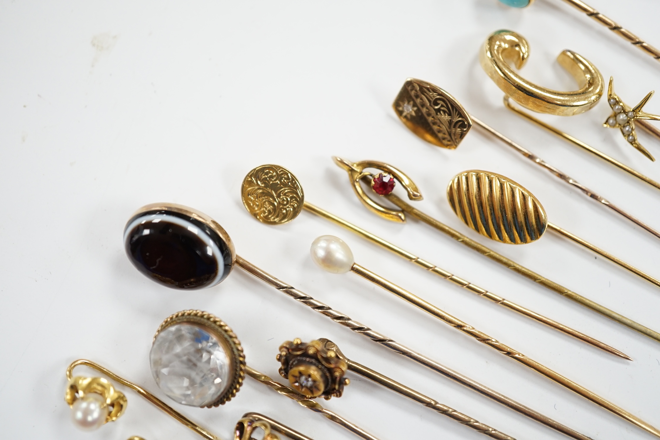 Fifteen assorted mainly early 20th century yellow metal and gem set stick pins, including diamond, seed pearl and banded agate, gross weight 23.1 grams.